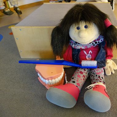 Handpuppe zeigt richtiges Zähneputzen